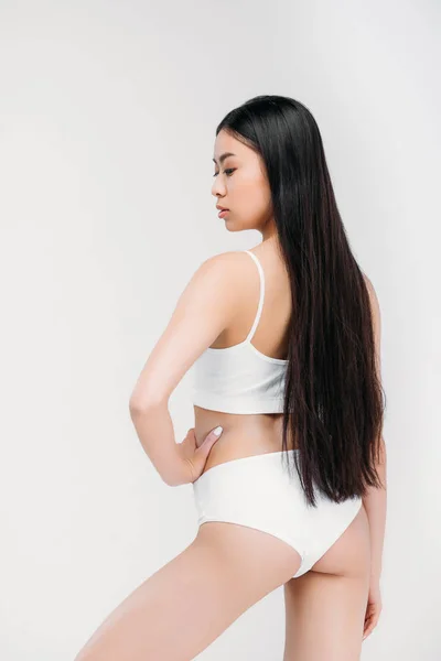 Hermosa chica asiática posando en ropa interior blanca, aislado en gris - foto de stock