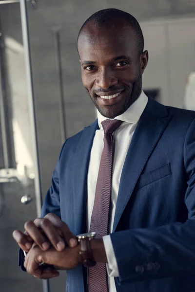 Close-up portrait of handsome young businessman in stylish suit and wristwatch looking at camera — Stock Photo