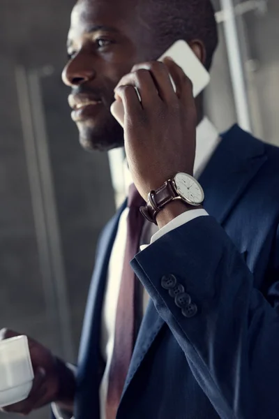 Close-up tiro de atraente jovem empresário com xícara de café falando por telefone — Fotografia de Stock