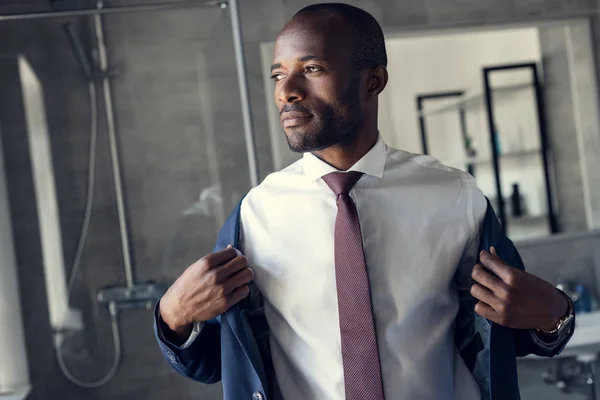 Handsome young businessman dressing up for work — Stock Photo