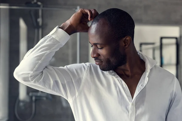 Schöner junger Mann im weißen Hemd mit Blick auf seine feuchten Achseln — Stockfoto