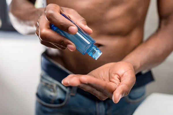 Plan recadré de l'homme afro-américain tenant lotion de rasage — Photo de stock