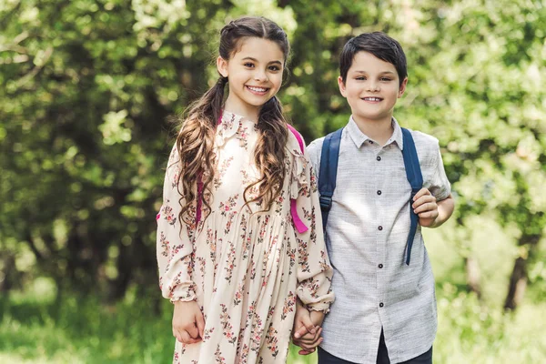 Bambini sorridenti che si tengono per mano mentre trascorrono del tempo insieme nel parco — Foto stock