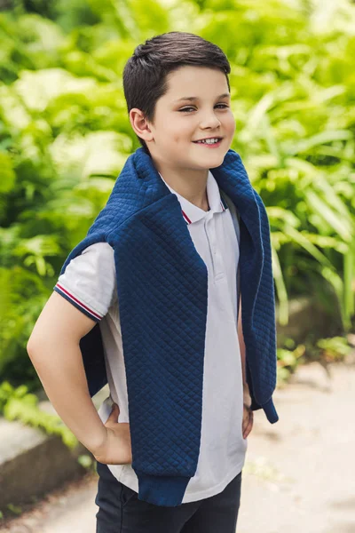 Happy kid with jumper over shoulders looking at camera — Stock Photo