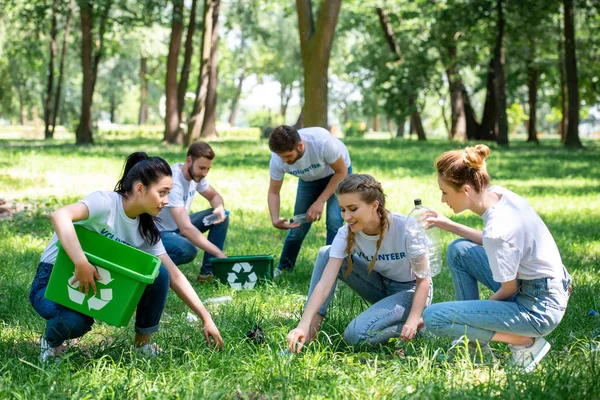 Молоді добровольці разом прибирають зелений парк — стокове фото