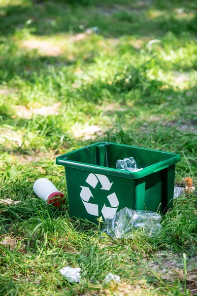 Boîte de recyclage et déchets en plastique sur la pelouse verte — Photo de stock