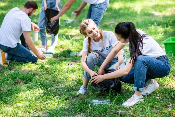 Young volunteers cleaning lawn in park — Stock Photo