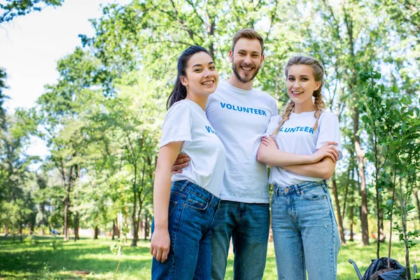 Jeunes bénévoles s'embrassant dans le parc ensemble — Photo de stock