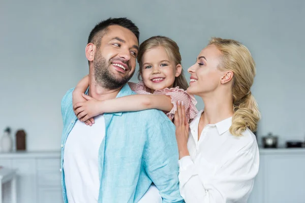 Familia feliz con un niño abrazándose y pasando tiempo juntos en casa - foto de stock