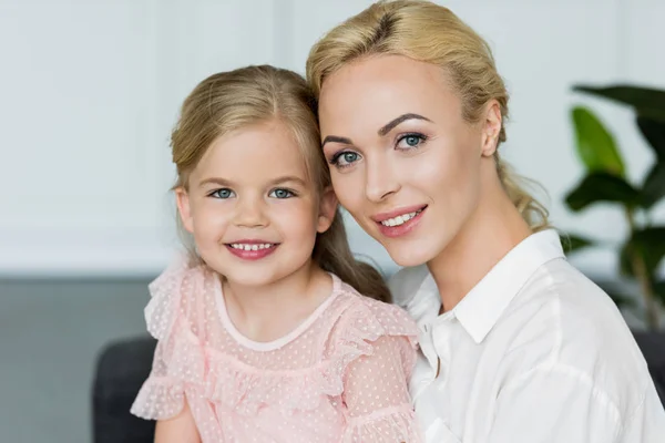 Portrait of beautiful happy mother and daughter smiling at camera — Stock Photo