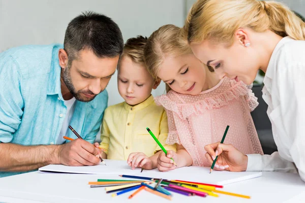 Dibujo familiar feliz con lápices de colores juntos en casa - foto de stock