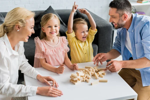 Happy family playing with wooden blocks at home — Stock Photo