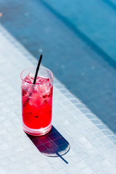 Close-up shot of glass of berry cocktail on poolside — Stock Photo