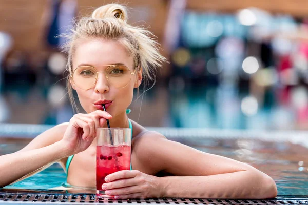 Bella giovane donna bere cocktail fresco a bordo piscina — Foto stock