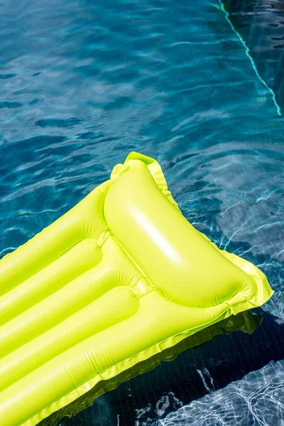 Tiro close-up de colchão inflável verde flutuando na piscina — Fotografia de Stock