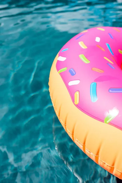 Primer plano de anillo inflable en forma de rosquilla flotando en la piscina - foto de stock