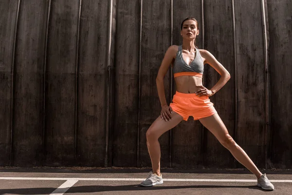 Attraktive Sportlerin streckt Beine auf dem Parkplatz — Stockfoto
