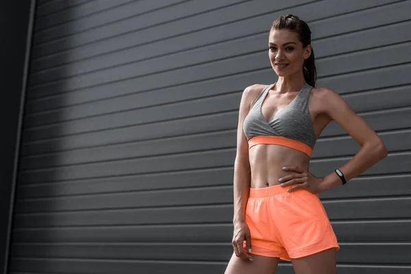 Smiling sportswoman posing in sportswear with fitness tracker — Stock Photo