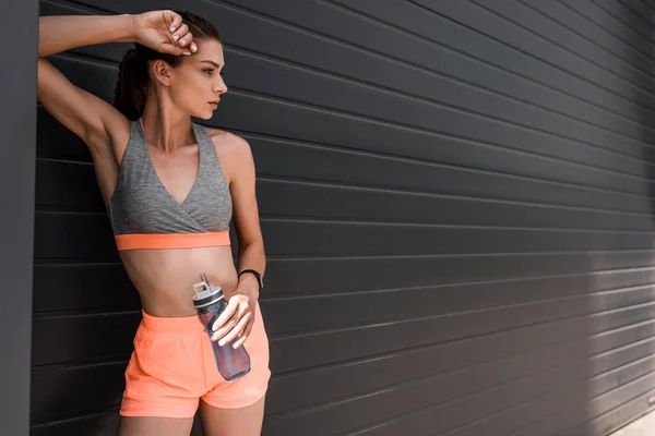 Sportlerin mit Fitness-Tracker und Wasserflasche — Stockfoto