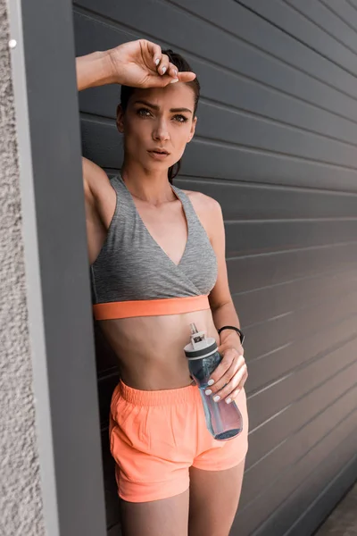 Bella donna atletica in possesso di bottiglia sportiva di acqua — Foto stock