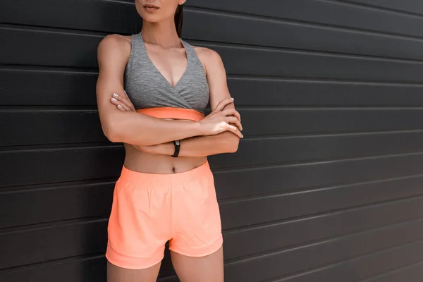 Cropped view of young sportswoman posing with crossed arms — Stock Photo