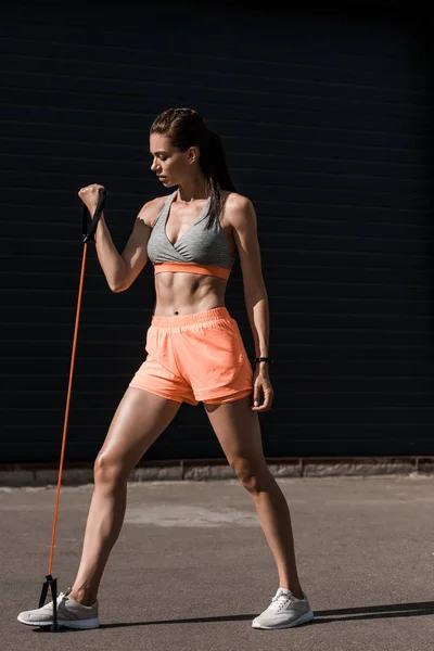 Mujer atlética joven haciendo ejercicio con banda elástica — Stock Photo