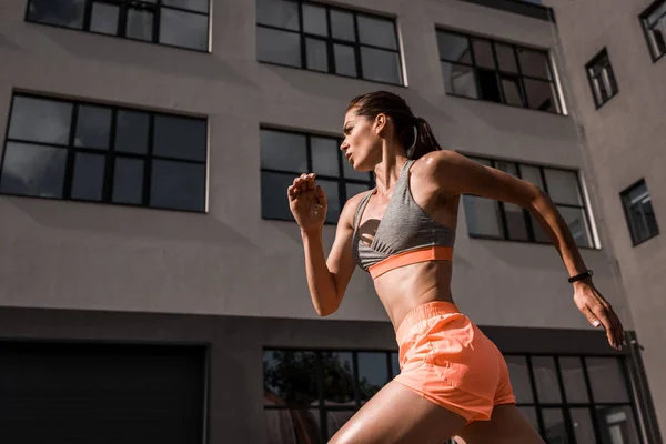 Junge konzentrierte Sportlerin joggt in der Stadt — Stockfoto