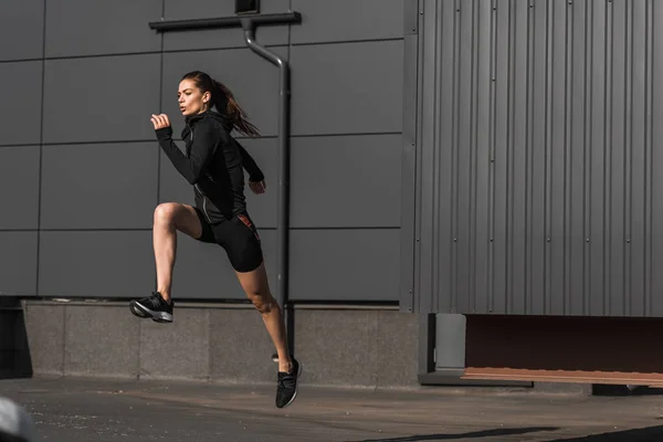 Young concentrated sportive runner training in city — Stock Photo