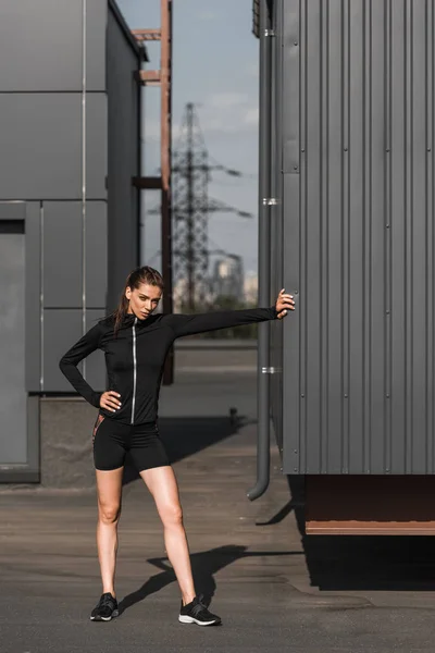 Jeune sportive fatiguée debout en vêtements de sport — Photo de stock