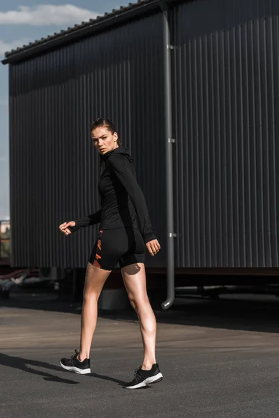 Привлекательная спортсменка, ходящая в черной теплой одежде — стоковое фото