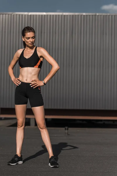 Jeune femme athlétique posant avec tracker de fitness en vêtements de sport — Photo de stock