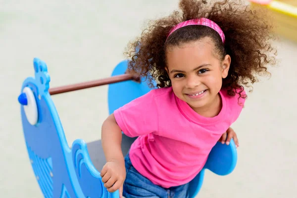 Retrato de encaracolado afro-americano criança tendo em playground — Fotografia de Stock