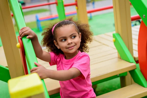 Вьющийся африканский американец, маленький ребенок смотрит вдаль на детскую площадку — стоковое фото