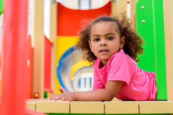 Retrato de encaracolado afro-americano criança se divertindo no parque infantil — Fotografia de Stock