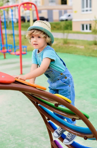 Adorable little boy in panama climbing on stairs at playground — Stock Photo