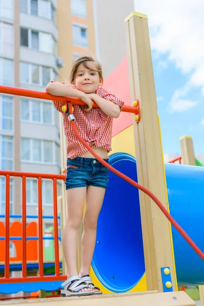 Vista angolo basso di adorabile bambino sorridente guardando la fotocamera al parco giochi — Foto stock