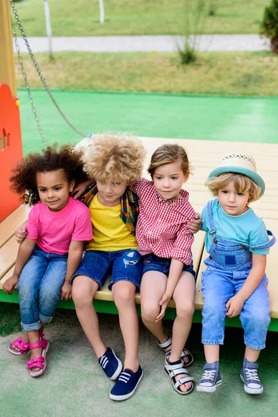 High angle view of multiethnic group of adorable children embracing each other at playground — Stock Photo
