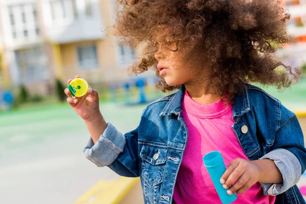 Curly african american little child playing with soap bubbles — Stock Photo