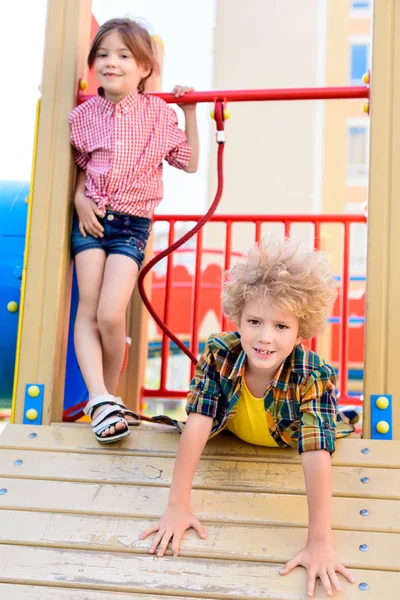 Foco seletivo de irmãozinho e irmã se divertindo no playground — Fotografia de Stock