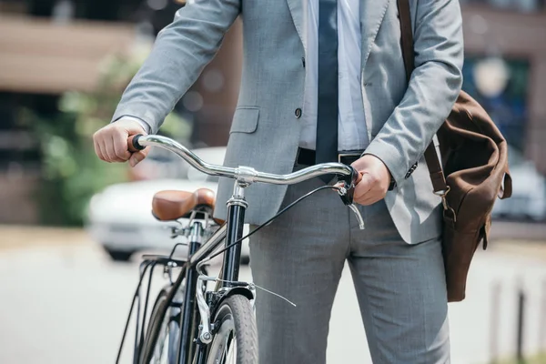 Imagem cortada de homem de negócios andando com bicicleta na rua na cidade — Fotografia de Stock