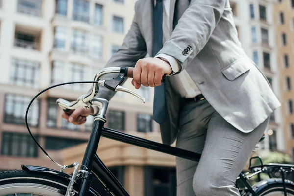 Vista parcial del hombre de negocios en traje de ciclismo en la ciudad - foto de stock