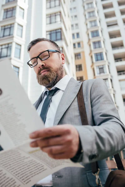 Barbuto uomo d'affari leggendo giornale in città — Foto stock