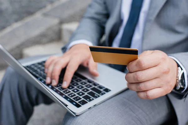 Обрізаний вид чоловіка, що купує онлайн з ноутбуком та кредитною карткою — стокове фото