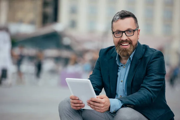Barba hombre de negocios con estilo en gafas usando tableta digital en la ciudad - foto de stock
