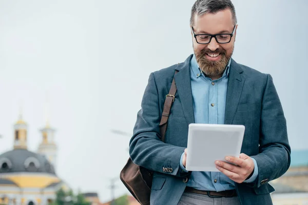 Борода бізнесмен в окулярах з використанням цифрового планшета в місті — стокове фото
