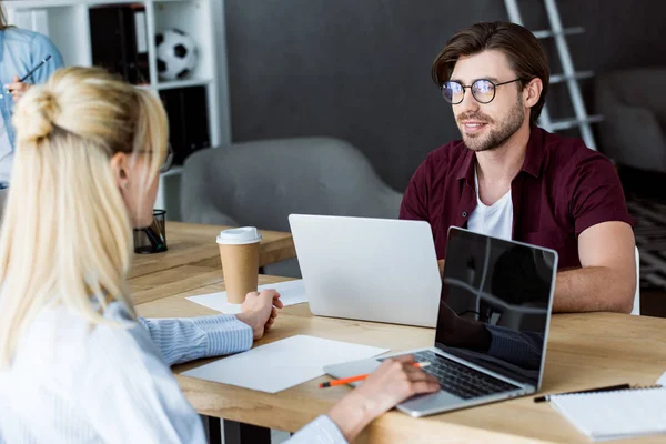 Männliche und weibliche Kollegen, die im Büro an einem Startup-Projekt arbeiten und einander betrachten — Stockfoto