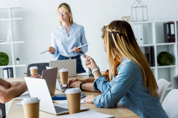 Team leader standing in front of colleagues working in office of startup project — Stock Photo