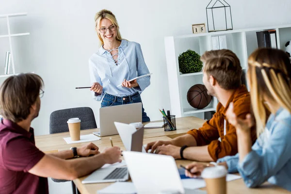 Collègues travaillant sur le projet de démarrage au bureau et à l'écoute du gestionnaire avec présentation — Photo de stock