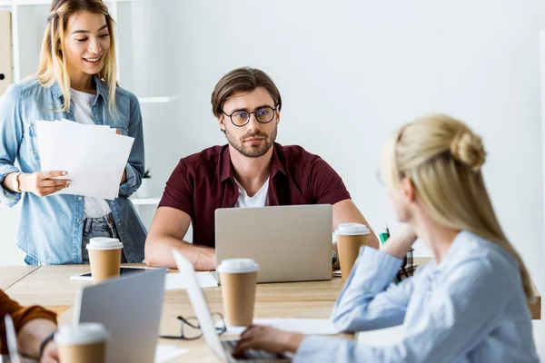 Colegas multiculturais trabalhando no projeto de startup no escritório e olhando uns para os outros — Fotografia de Stock