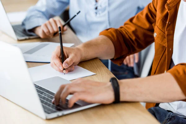 Imagem cortada de colegas usando laptops para trabalhar em novo projeto de inicialização no escritório — Fotografia de Stock